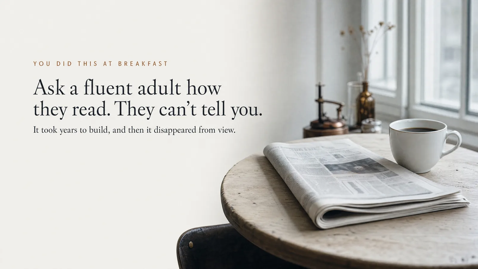 Slide: You did this at breakfast — Ask a fluent adult how they read. They can't tell you. It took years to build, and then it disappeared from view. A folded newspaper and a cup of coffee on a breakfast table.
